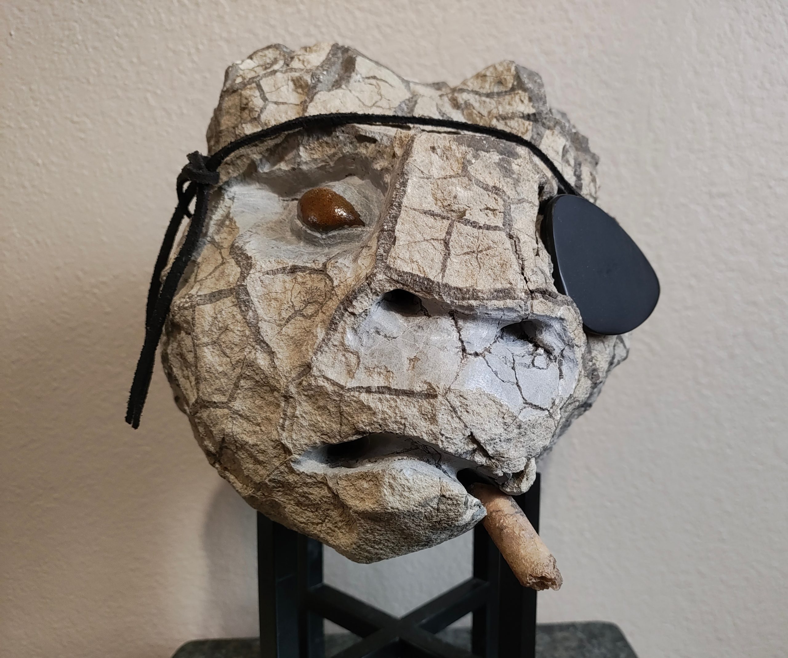 Painting of a dog with yellow, red and green pillows sitting on a piece of furniture.